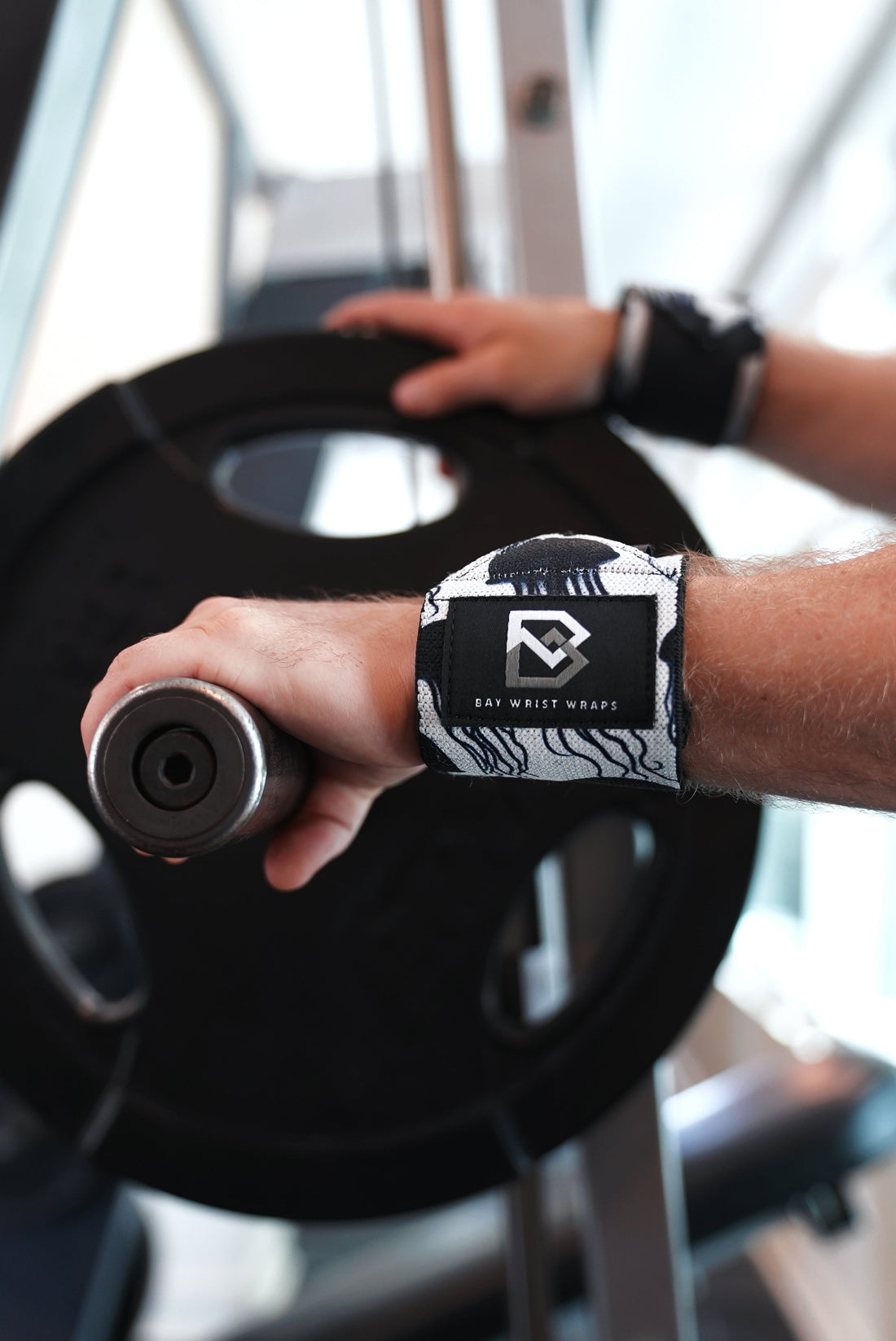 Lifting straps and wrist wraps by Bay Gear Co. laid out for a push-pull workout