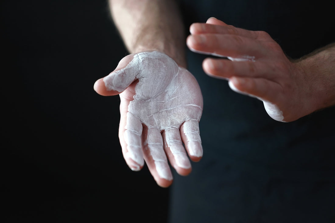 How to improve grip strength for deadlifts: chalked hook grip on a barbell with Bay Gear Co. lifting straps and liquid chalk
